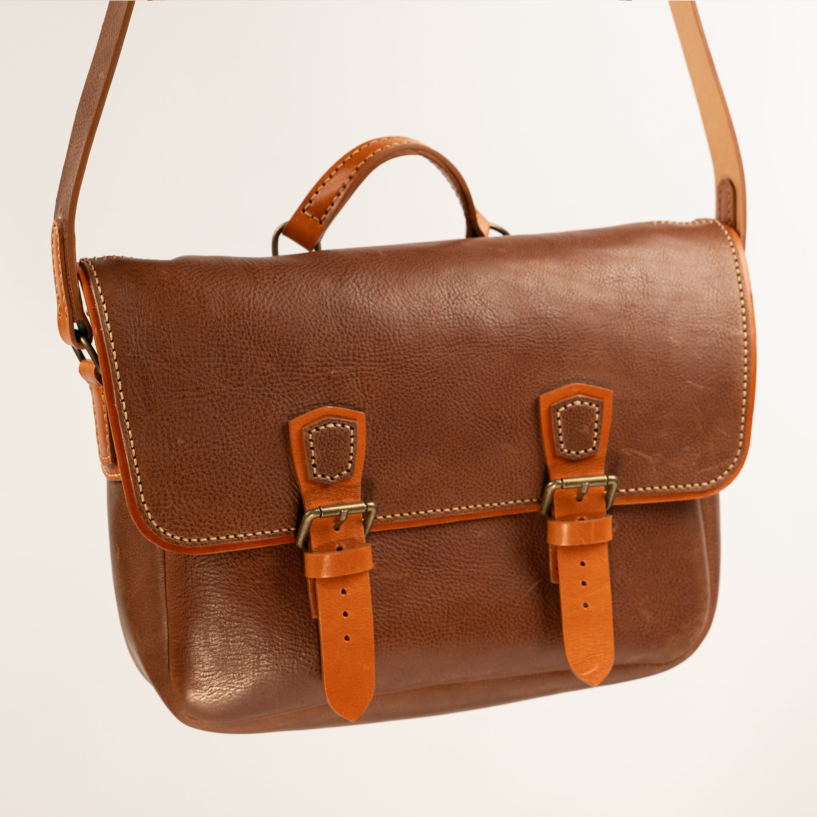 Handmade Morgan Messenger Bag in brown leather with adjustable strap against a white background. Leathercraft design by Vasile and Pavel.