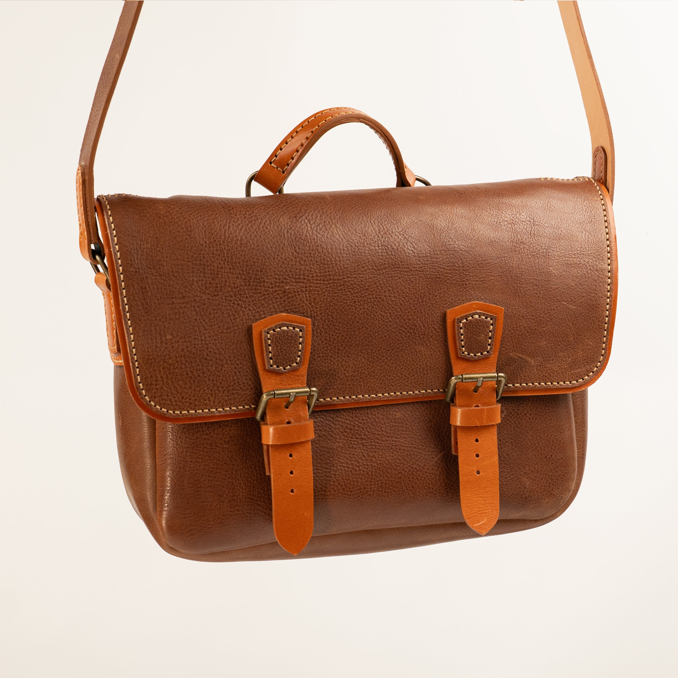 Handmade Morgan Messenger Bag in brown leather with adjustable strap against a white background. Leathercraft design by Vasile and Pavel.