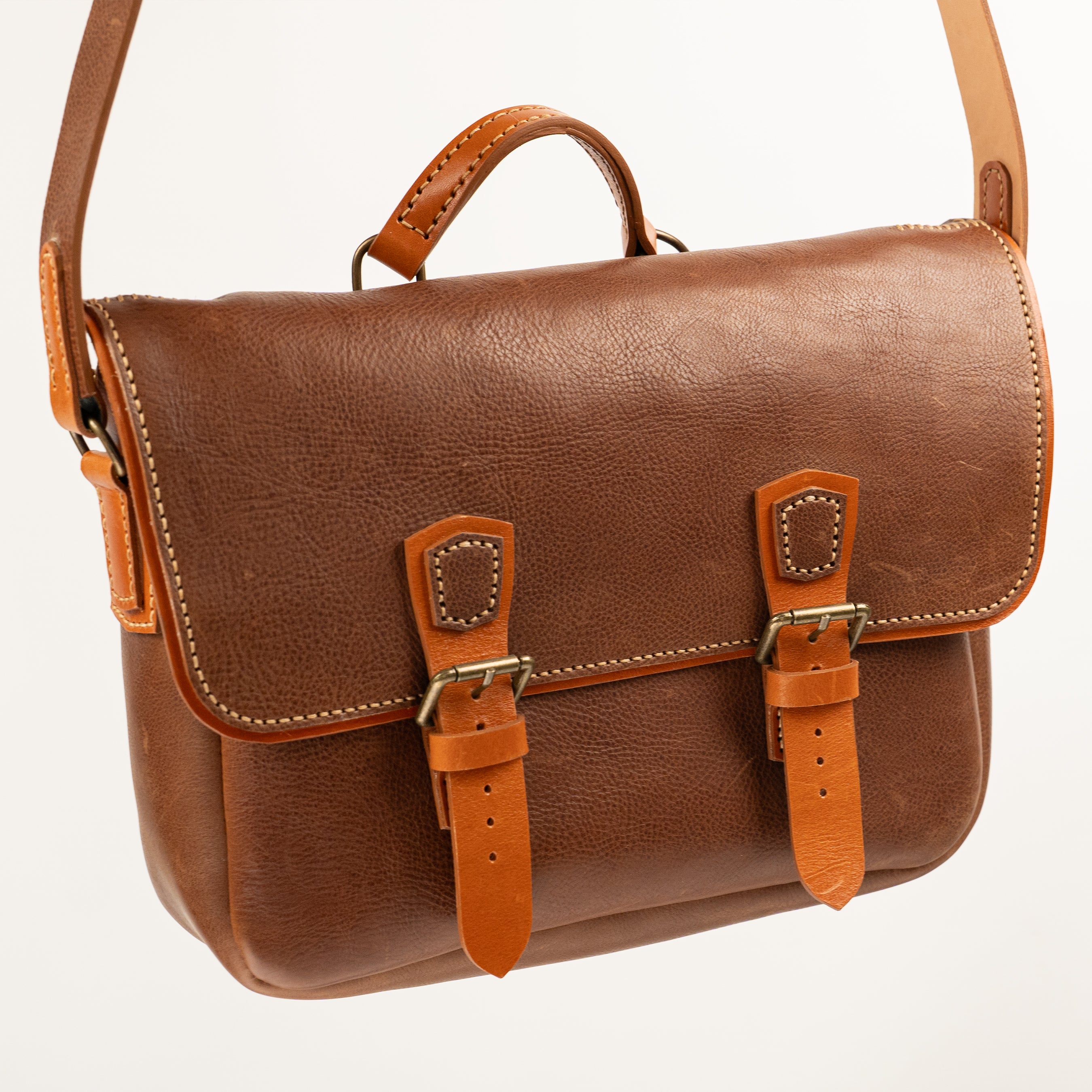 Handmade Morgan Messenger Bag in brown leather with adjustable strap against a white background. Leathercraft design by Vasile and Pavel.
