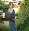 Photo with a young woman wearing the Selena Leather Tote Bag designed by Vasile and Pavel Leather Patterns in the grass. Showcase  for the DF Pattern + DXF + Video for Selena Tote Bag outdoors.